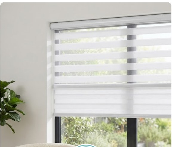 Zebra blind in a bright home living room beside an armchair