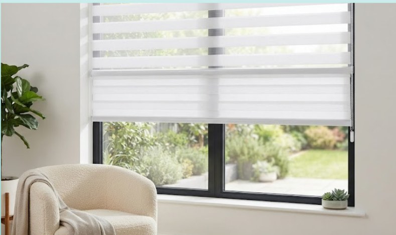 Manual zebra blind fitted over a garden-facing window beside an armchair
