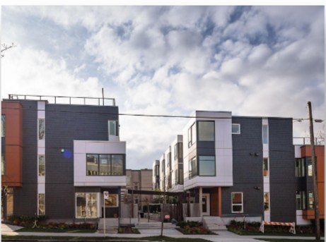 Modern multi-tone townhome development under a cloudy sky