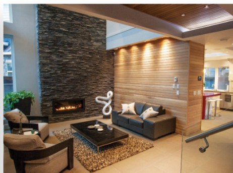 Living room with a stone fireplace wall and wood ceiling detail