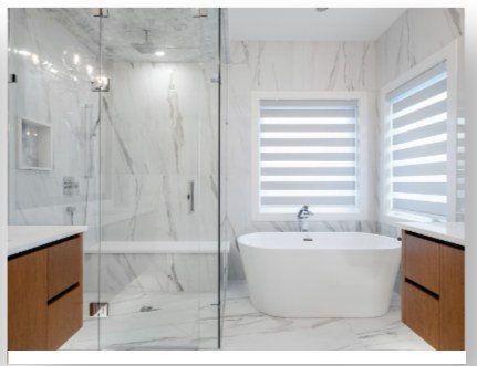 Marble bathroom with a freestanding tub and zebra blinds
