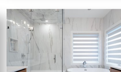 Marble bathroom with a freestanding tub and zebra blinds