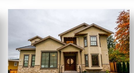 Stucco and stone family home with autumn landscaping